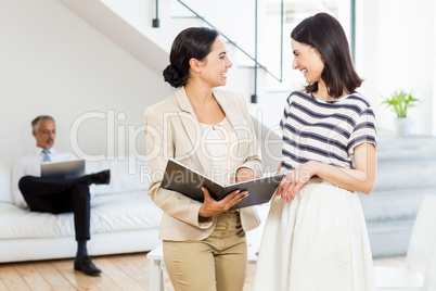 Businesswoman and a colleague interacting and holding diary