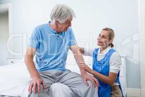 Nurse comforting senior man at hospital