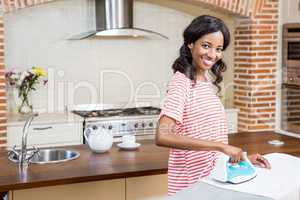 Young woman ironing her clothes