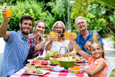 Family having breakfast at table in yard