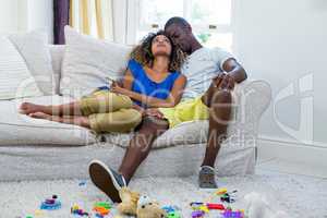 Couple embracing while sitting on sofa in living room