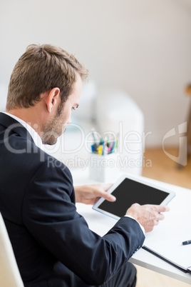 Businessman using digital tablet at desk