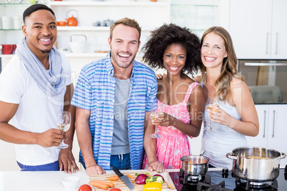 Friends holding glasses of wine in kitchen