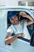Portrait of smiling delivery man showing car keys