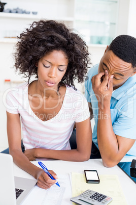 Worried young couple calculating bills