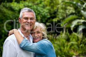 Cheerful senior couple against plants