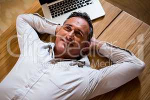 Thoughtful man lying on desk