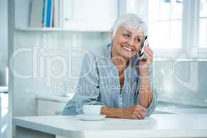 Smiling retired woman talking on phone