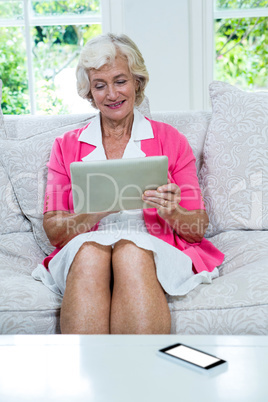 Senior woman using digital tablet at home