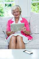 Senior woman using digital tablet at home