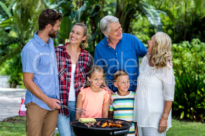 Front view of family griling food at yard