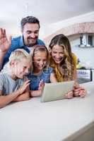 Parents and kids using digital tablet in kitchen