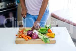 Mid-section of woman chopping vegetable in kitchen