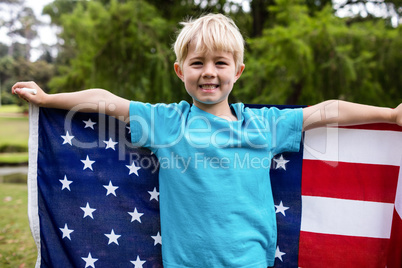 Boy holding an american flag in the park