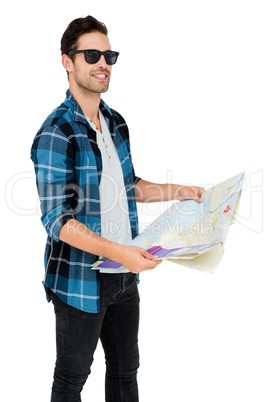 Young man in sunglasses holding map