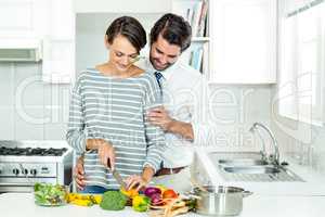 Couple chopping vegetables at table in kitchen