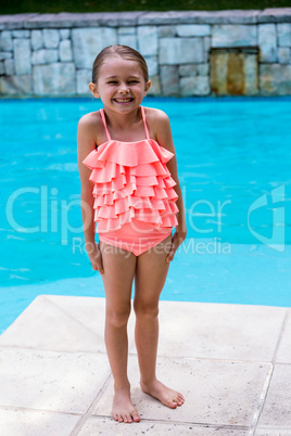 Girl standing by swimming pool