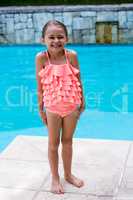 Girl standing by swimming pool