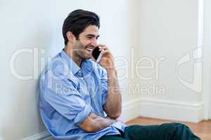 Man sitting on floor and talking on phone