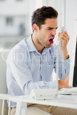 Businessman shouting in frustration on phone