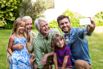 Happy father taking selfie with family in yard