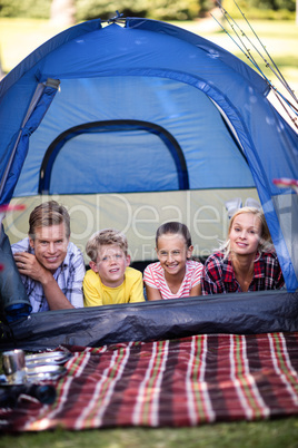 Happy family lying in a tent
