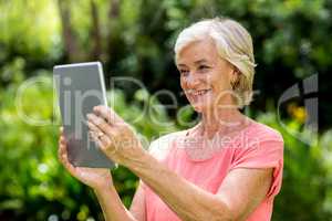 Senior woman with tablet at yard