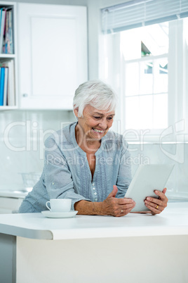 Happy senior woman using digital tablet