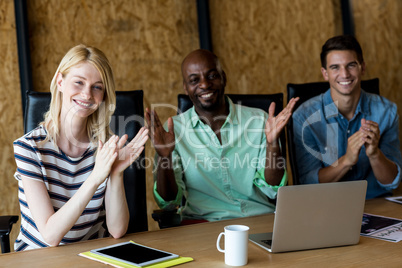 Colleagues applauding at their desk