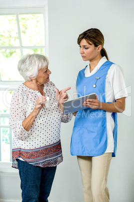 Senior woman talking with nurse