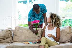 Young man offering a flower to woman