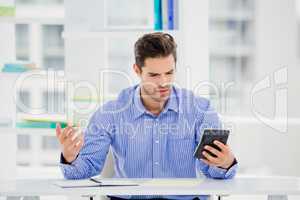 Businessman calculating accounts on a calculator