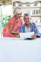 Wife discussing with senior man on documents at table
