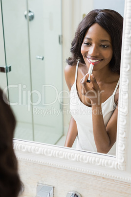 Young woman applying lipstick