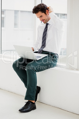 Businessman using laptop and taking notes