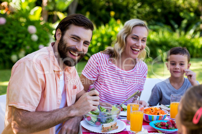 Cheerful family enjoying breakfast at yard