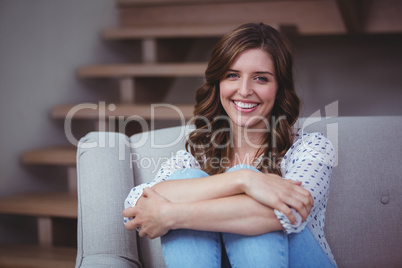 Portrait of beautiful woman sitting on sofa