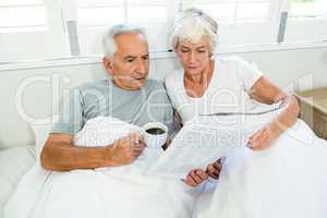 High angle view of senior couple reading newspaper