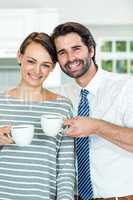 Smiling couple drinking coffee at home