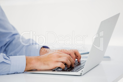Mid-section of businessman working on laptop