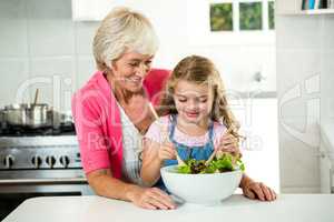 Happy granny and girl preparing vegetables