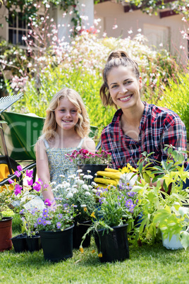 Portrait of mother and daughter gardening together in garden