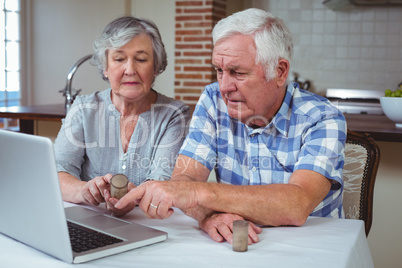 Senior couple searching pills with help of laptop