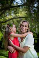 Happy mother and daughter relaxing in yard