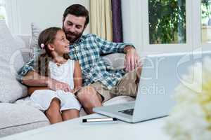 Smiling father and daughter on sofa