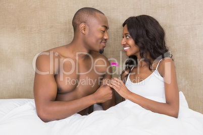 Young man offering a flower to woman