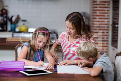 Mother helping kids with their homework