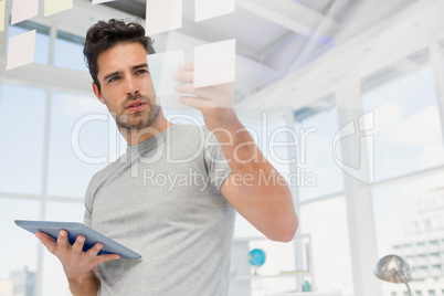 Man holding digital tablet and looking at sticky notes Man holding digital tablet and looking at sticky notes
