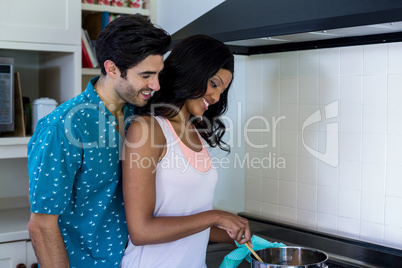 Young couple cooking food together in kitchen