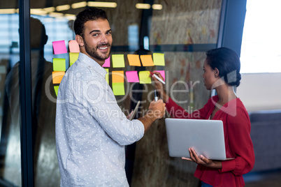 Colleagues writing on sticky notes